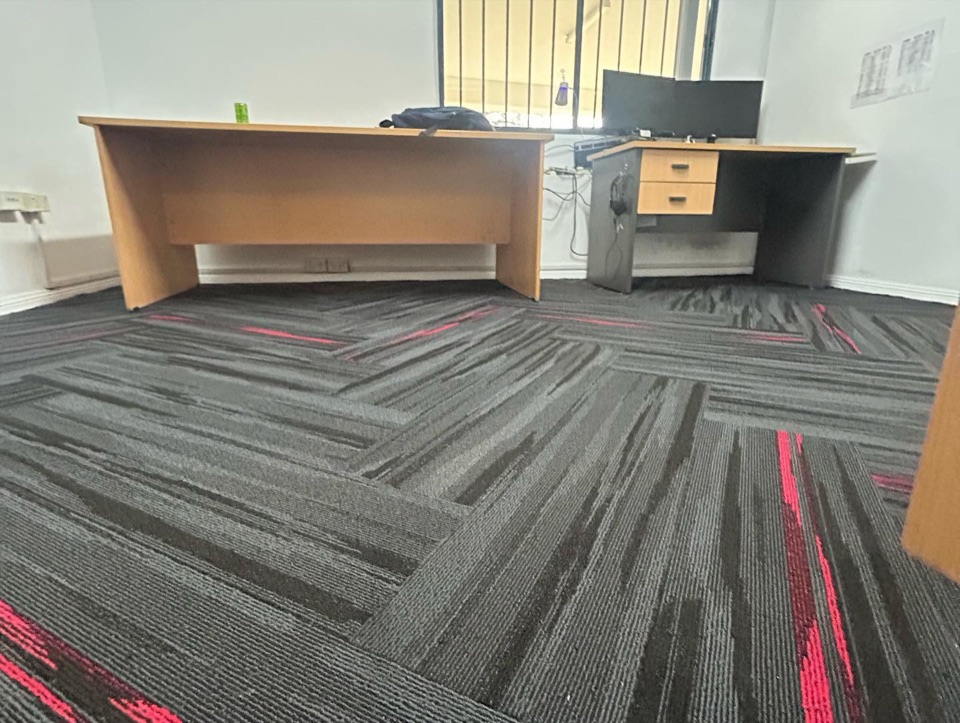 Carpet tiles laid herringbone around the office desks