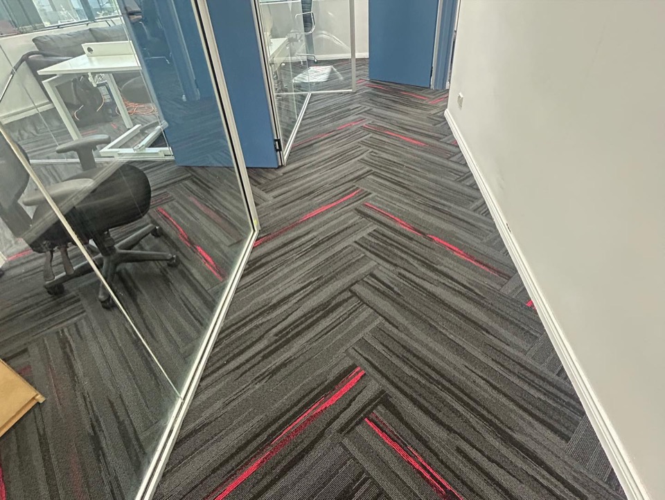 Carpet tiles going down in a herringbone pattern