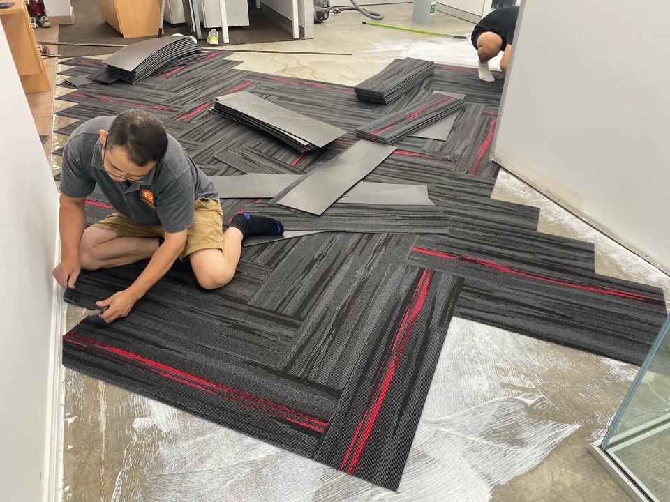 Gluing down the herringbone carpet tiles