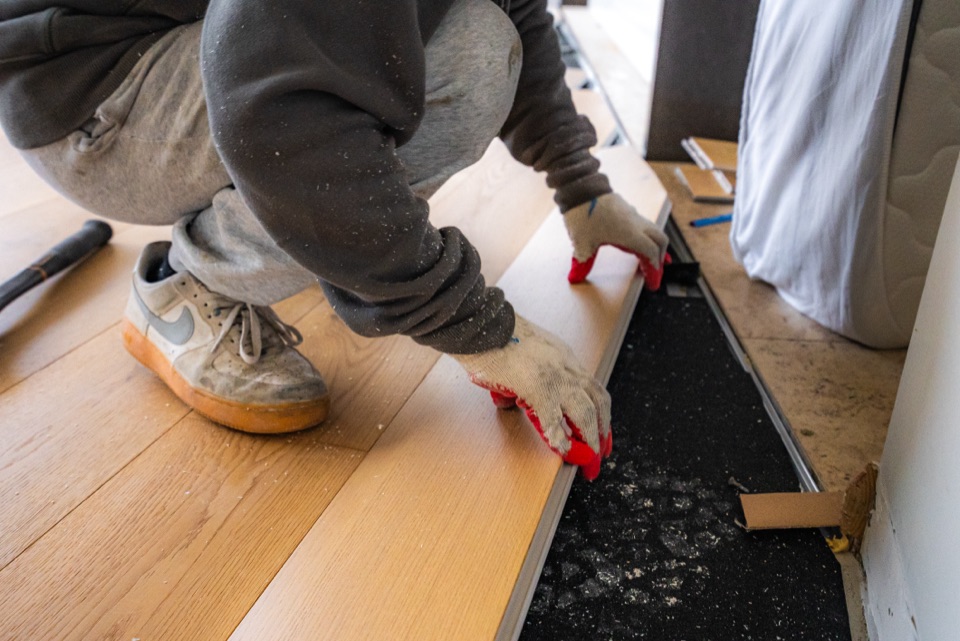 First oak boards going down over black underlay
