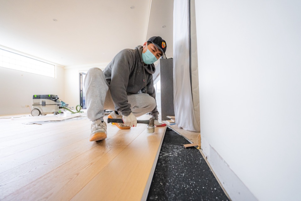 Tapping each board home over acoustic underlay