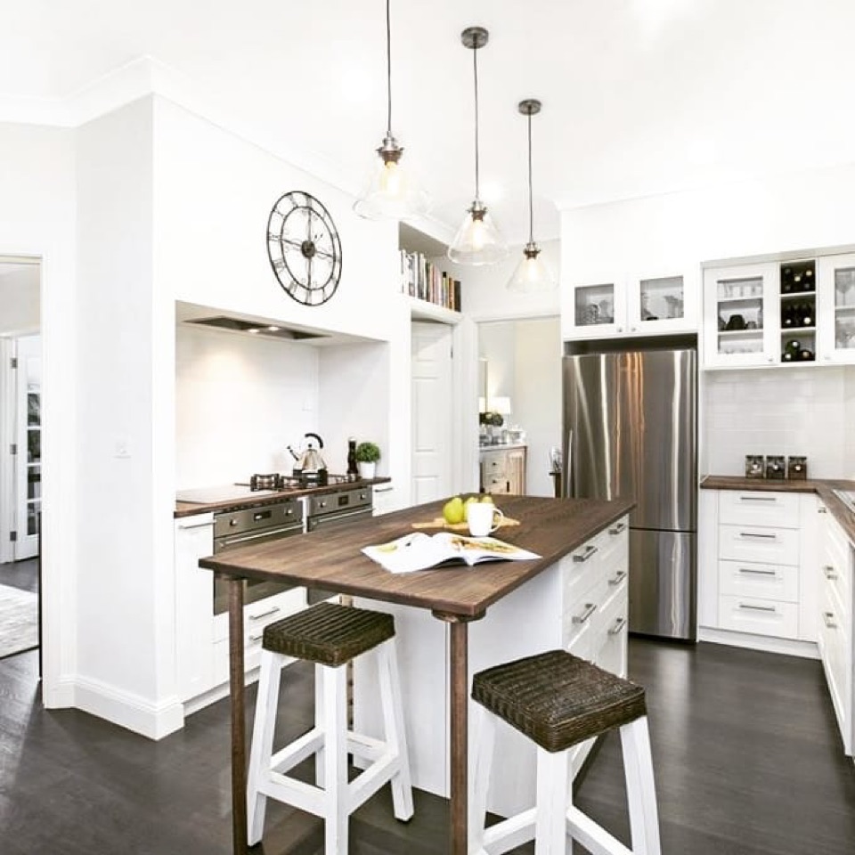 Dark hybrid floor grounds the white kitchen