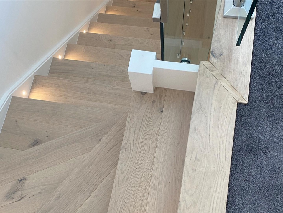 Oak stairs with step lights and glass balustrade