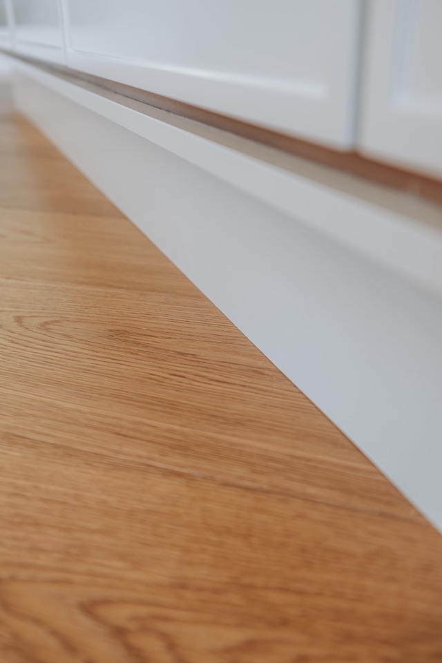 The floor running clean to the cabinetry