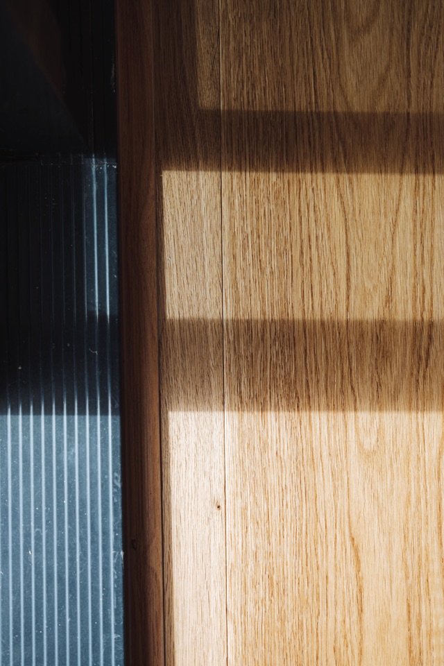 Window light over the oak beside the door frame